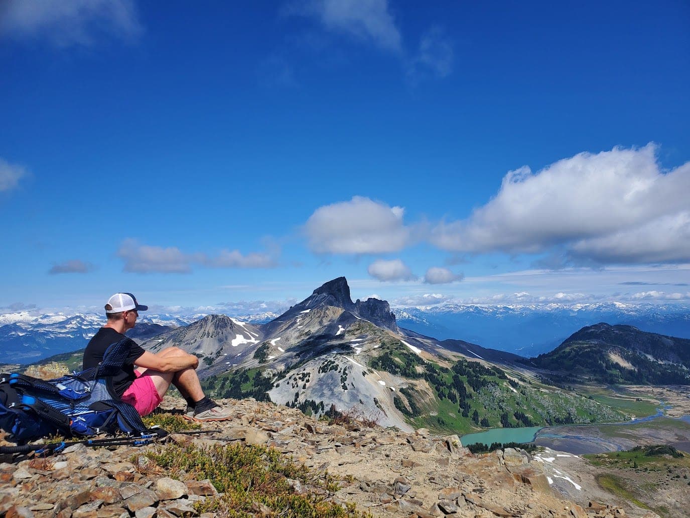 JME Maxwell sitting on a summit ridge in Garibaldi Provincial Park, looking out at Black Tusk.