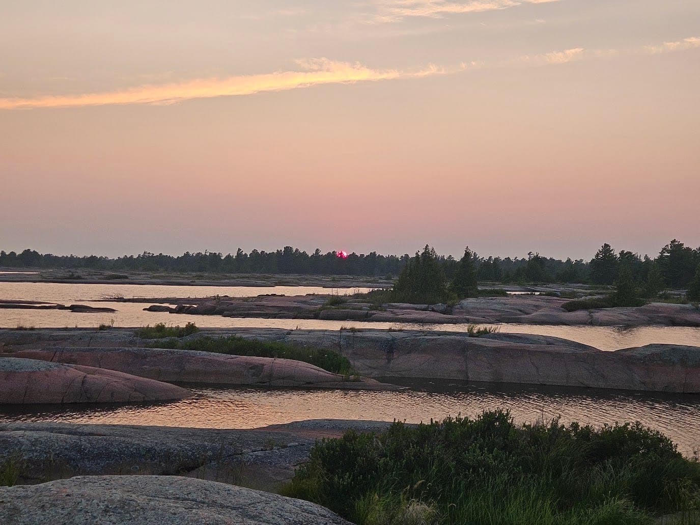 Sunset over the flat pink granite and channels of northern Georgian Bay.